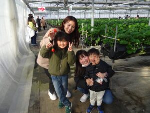 摘みたてのいちごを手に笑顔の社員